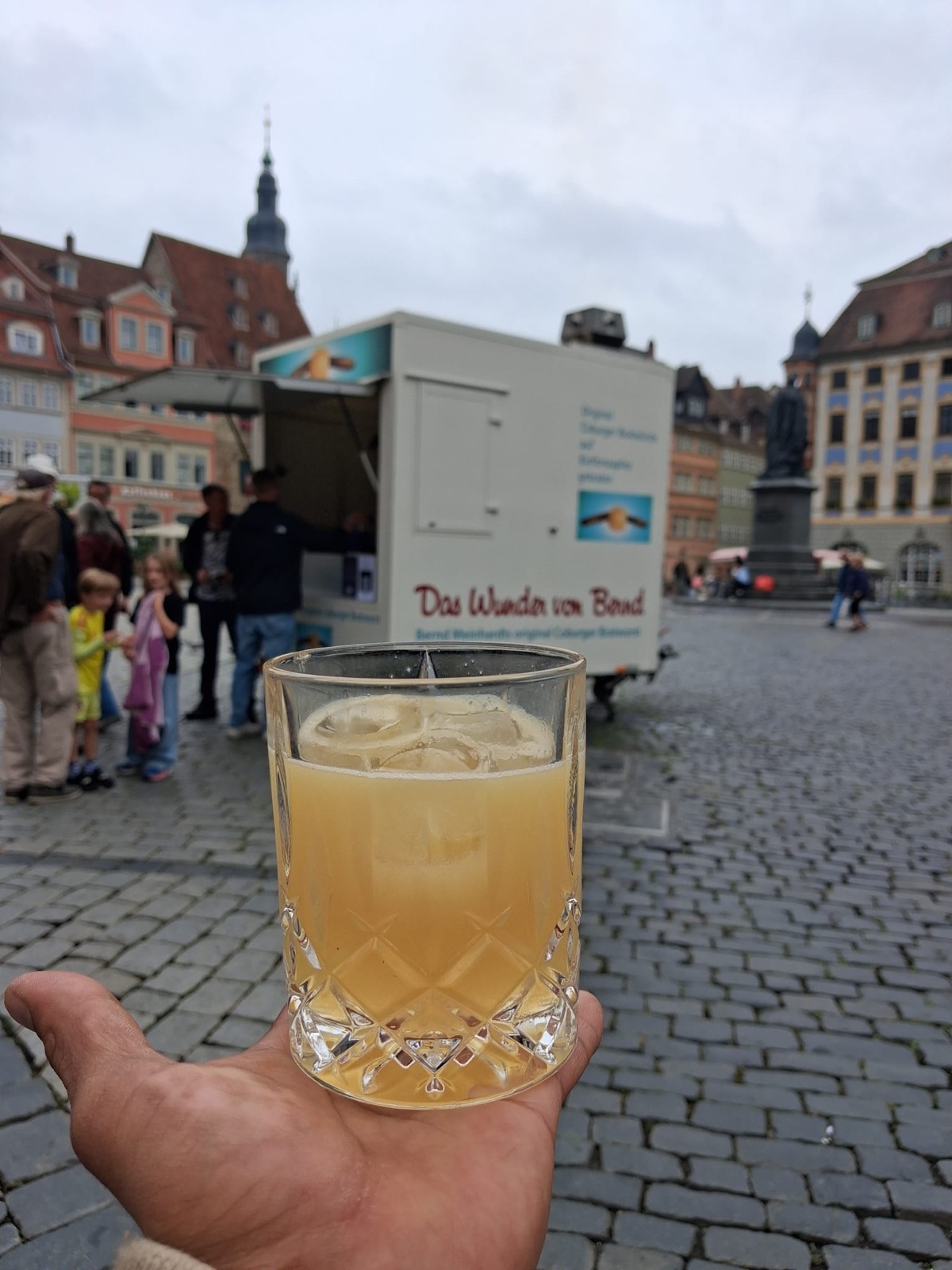 Whiskey Bratwurst Sour auf dem Coburger Marktplatz, im Hintergrund der Bratwurststand