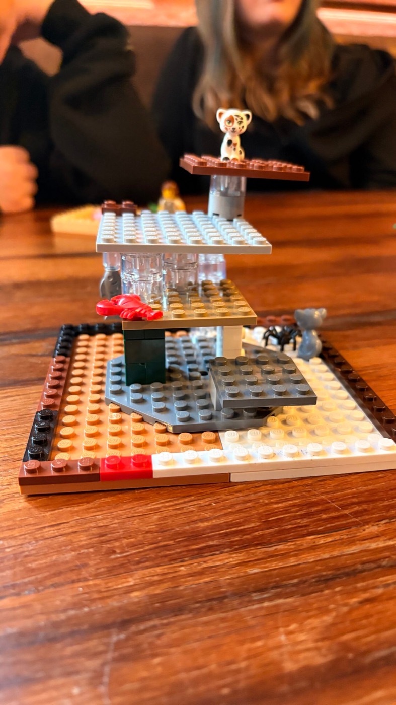 Mehrstöckiger Lego-Kratzbaum mit gelbem Kätzchen auf der oberen Plattform