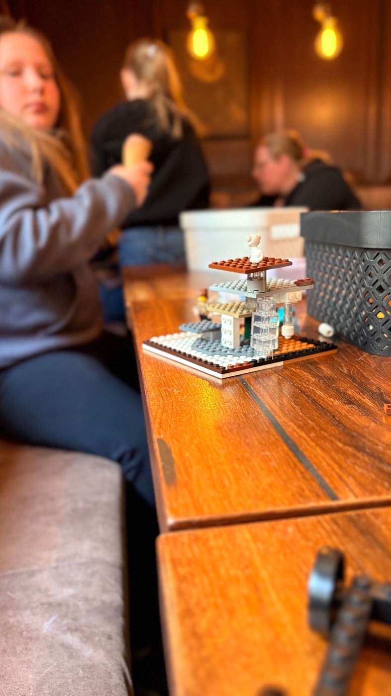 Kind im Hintergrund neben fertigem Lego-Werk im Vordergrund