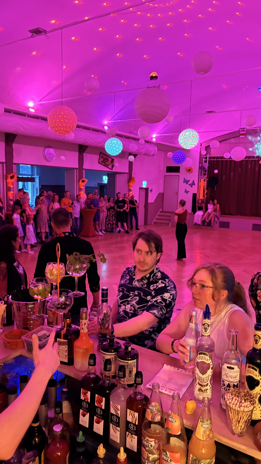 Gäste an der Casa-Blumen-Bar bei der Fiesta Latina, Bartender beim Zubereiten der Drinks
