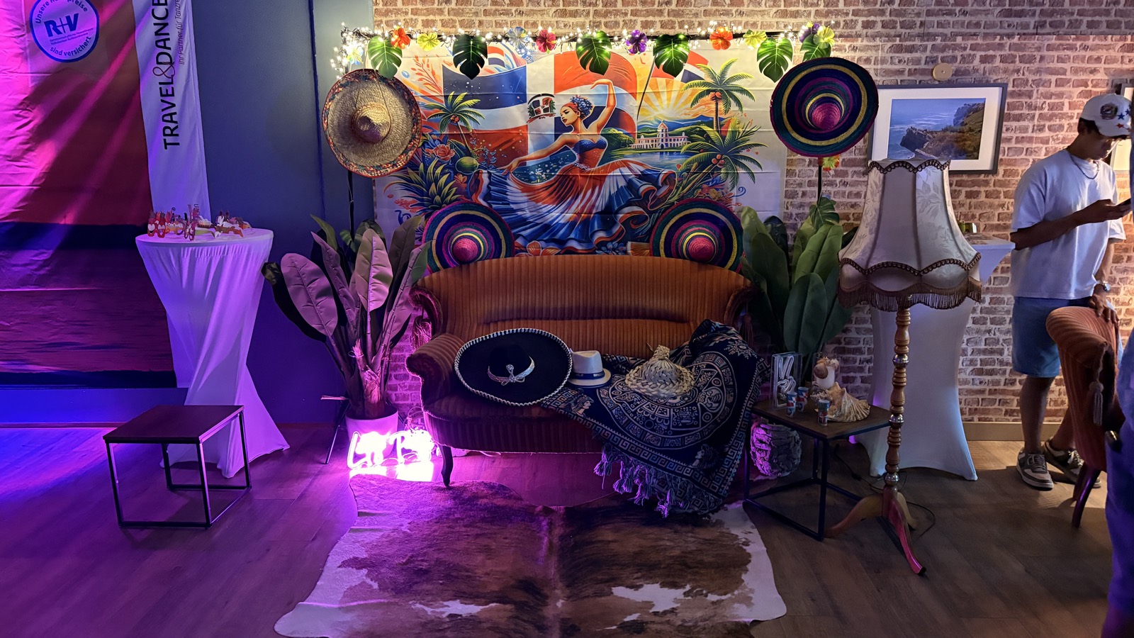 Foto-Ecke bei der Noche Latina mit tropischem Wandbild, Sombreros und oranger Couch