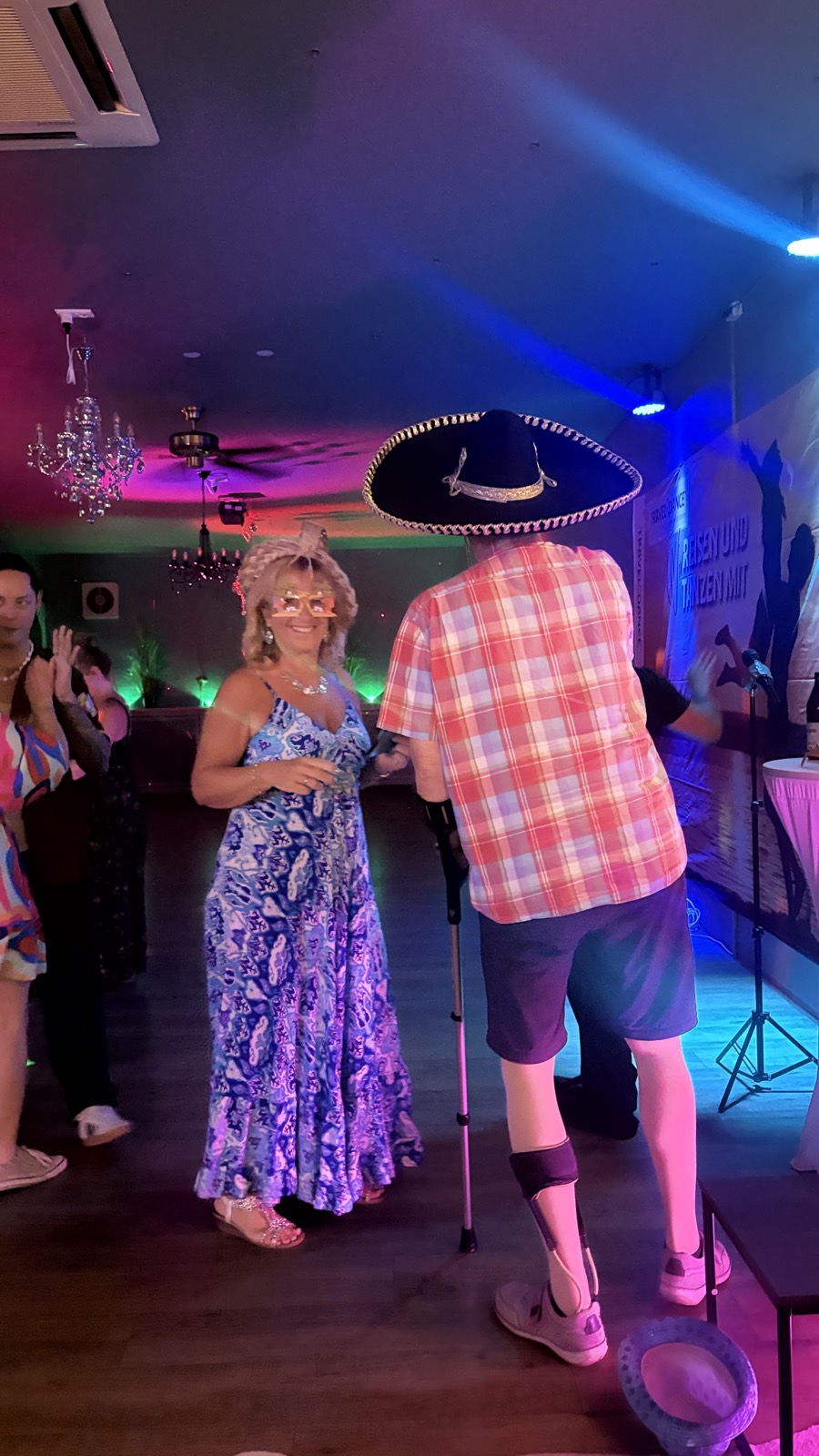 Gäste tanzen mit Sombrero auf der Tanzfläche der Noche Latina im blauen Licht