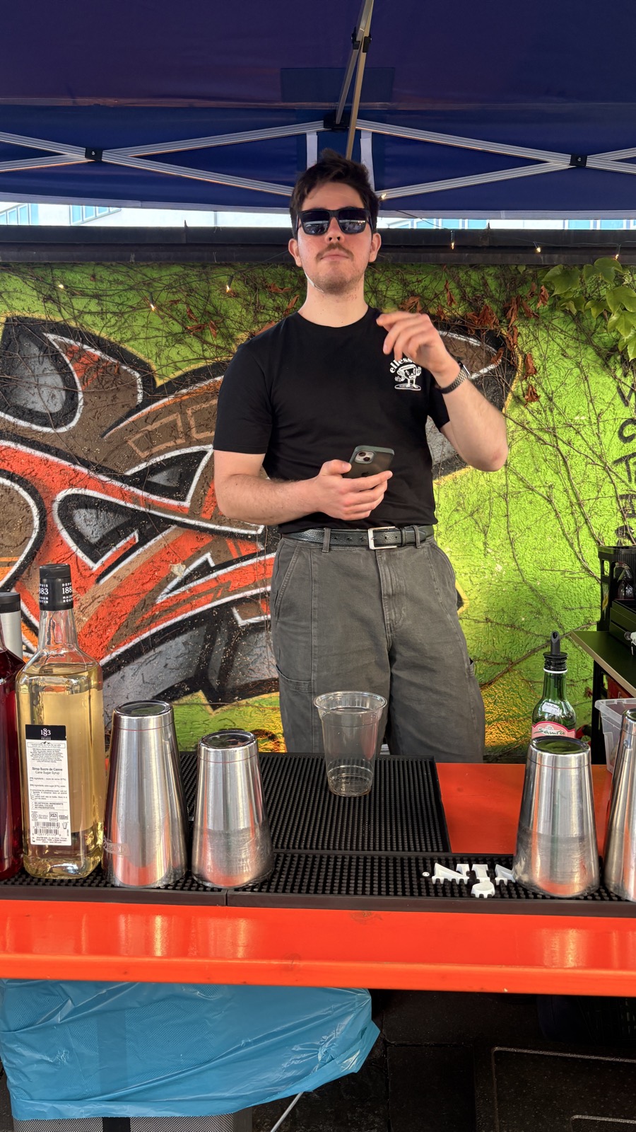 Barkeeper von Casa Blumen an der Open-Air-Bar vor der Graffiti-Wand beim Hoffest WirGestalten