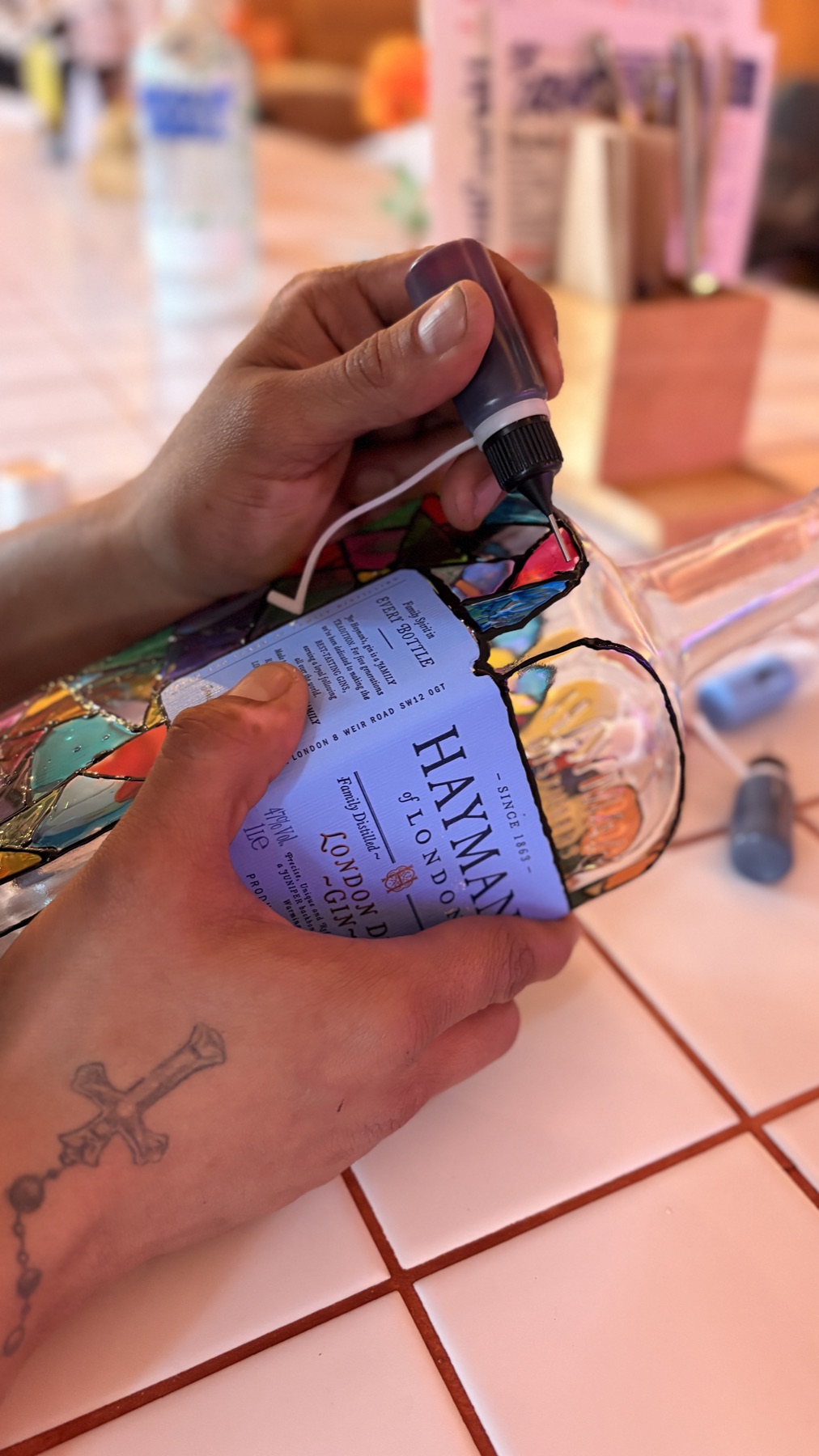 Hände bemalen ein Glas im Workshop