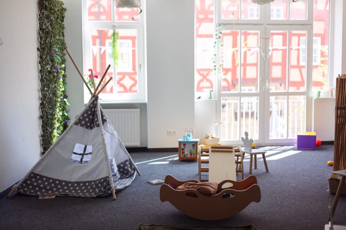 Kreativraum im Obergeschoss mit Tipi, Spielzeug und großen Fenstern zum Fachwerk