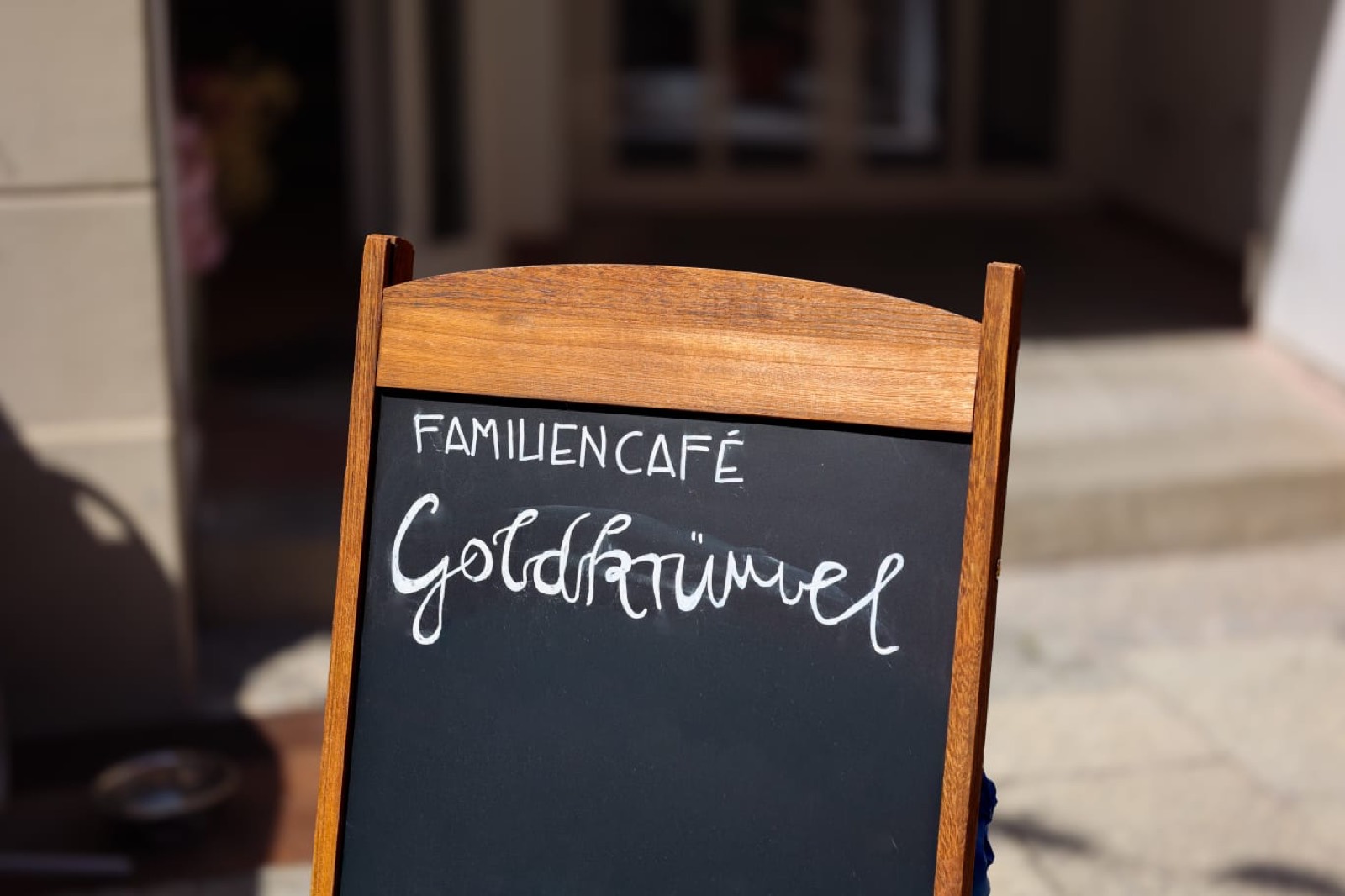 Kreidetafel des Familiencafés Goldkrümel in der Sonne