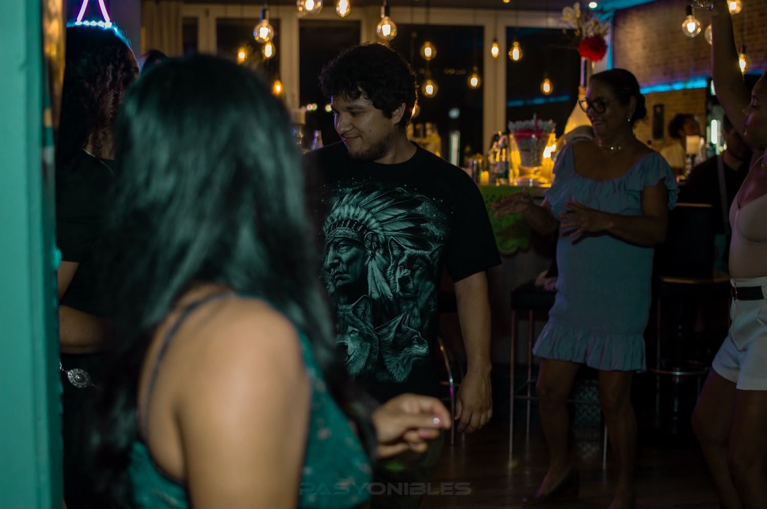 Gäste tanzen und klatschen vor der Bar bei der Noche Latina